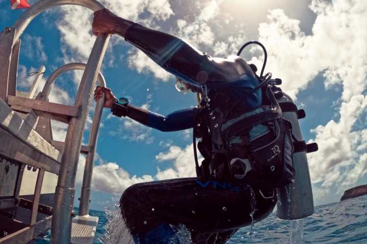 a scuba diver boarding the boat ladder